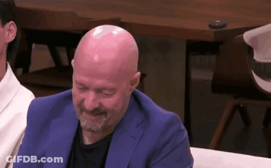 Bald Man With Beard In Blue Suit Laughing On Couch GIF