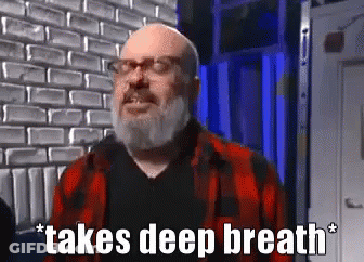 Bald Man With Beard In Glasses And Plaid Shirt Taking Deep Breath GIF