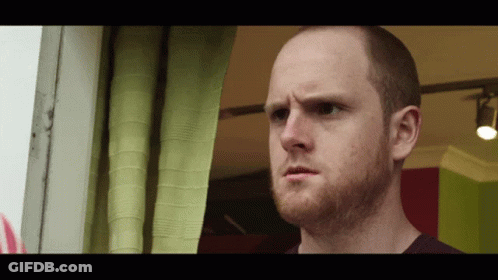 Bald Man With Beard Looking Out Window GIF