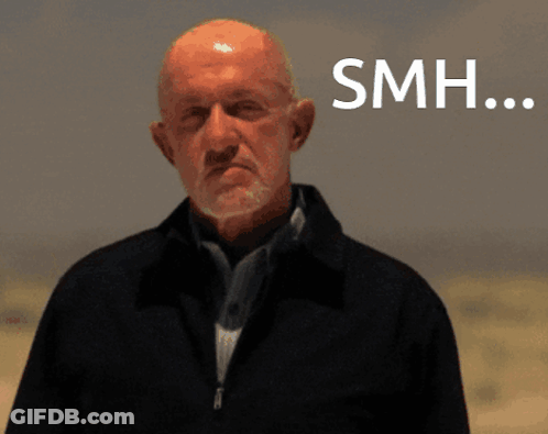 Bald Man With Beard Standing In Front Of SMH Sign GIF