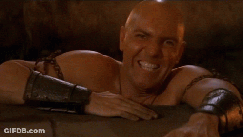 Bald Man With Chains Laying Down GIF
