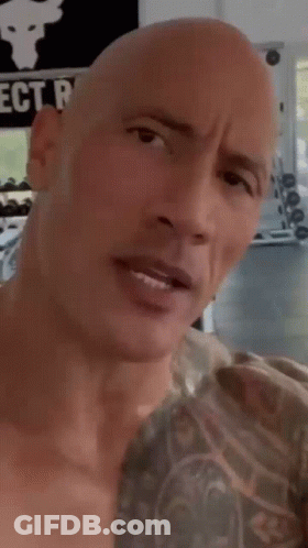 Bald Man With Chest Tattoo Looking At Camera GIF
