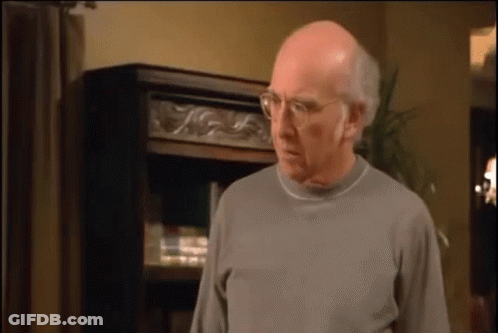 Bald Man With Glasses And Gray Sweater Bookshelf GIF