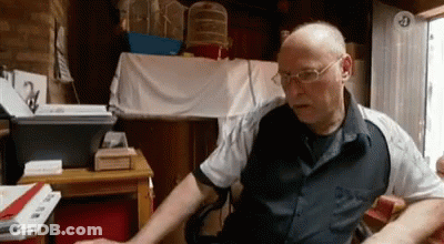 Bald Man With Glasses At Desk With Keyboard GIF