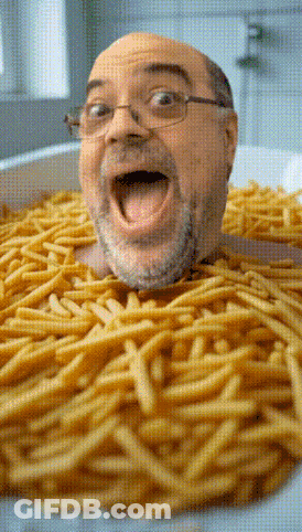 Bald Man With Glasses Laying In Bowl Of French Fries GIF