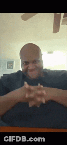 Bald Man With Hands Folded At Table GIF