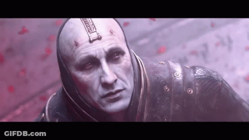 Bald Man With Hood In Front Of Red Wall GIF