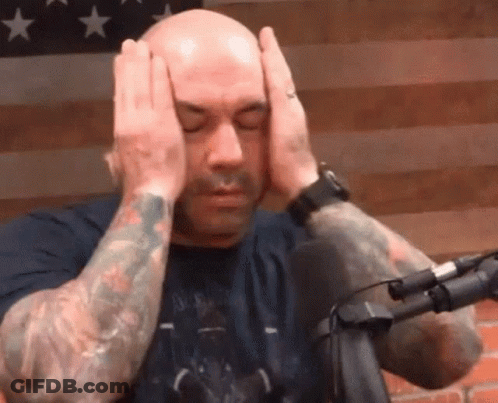 Bald Man With Tattoos Covering Head At Microphone GIF