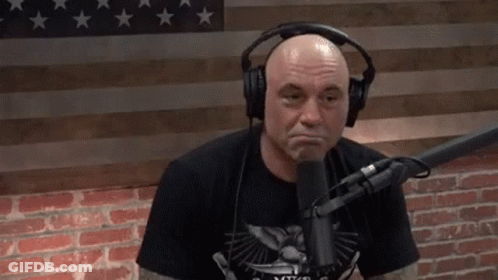 Bald Tattooed Man Covering Head At Microphone GIF