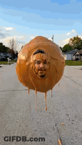 Balloon With Man's Face Floating Above Street GIF