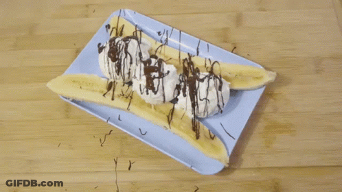 Banana Split With Whipped Cream And Chocolate Drizzle On Blue Plate GIF