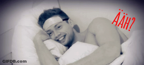 Bandaged Man Laying In Bed Saying Aah GIF