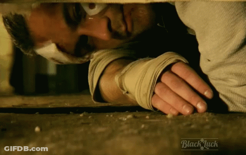 Bandaged Man Lying On Ground Saying Black Luck GIF