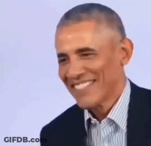 Barack Obama Is Smiling While Wearing A Suit And A Striped Shirt . GIF