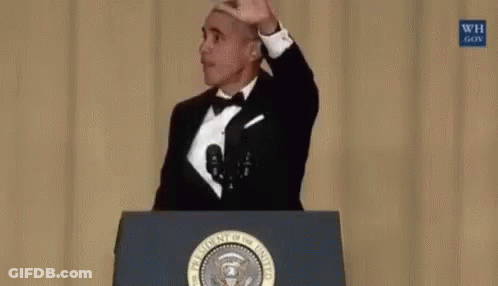 Barack Obama Is Standing At A Podium Holding A Microphone In His Hand . GIF