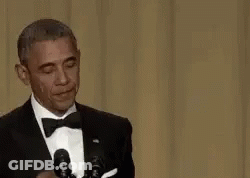 Barack Obama Is Wearing A Tuxedo And Bow Tie While Giving A Speech In Front Of Microphones . GIF