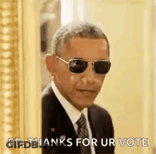 Barack Obama Is Wearing Sunglasses And A Suit And Tie While Standing In Front Of A Picture Frame . GIF