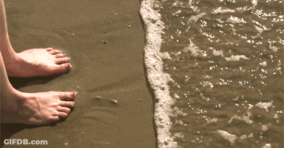 Bare Feet On The Sand While Waves Coming In GIF