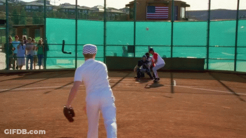 Baseball Game On Field With American Flag Behind Fence GIF