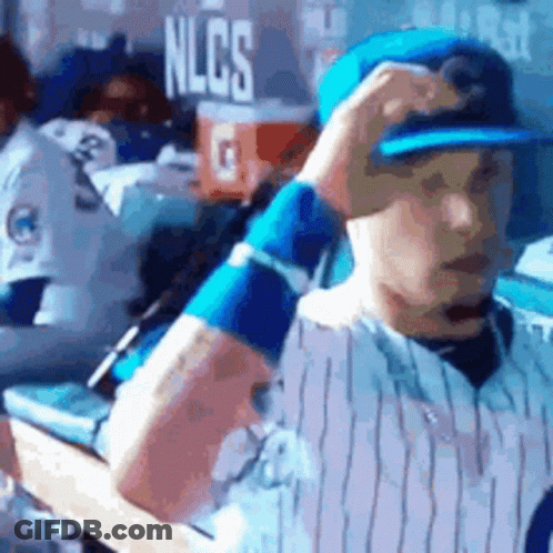 Baseball Player Adjusting Hat In Dugout GIF