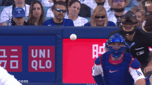 Baseball Player Catching Ball In Front Of Uniqlo Ad GIF
