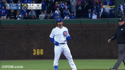 Baseball Player In Front Of Cubs Scoreboard GIF