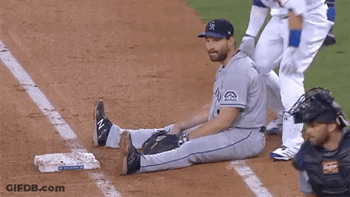 Baseball Player Stretching On Base While Catcher Watches GIF