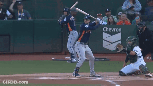 Baseball Player Swinging At Pitch Before Chevron Sign GIF