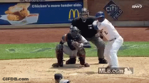 Baseball Player Swinging Bat At Ball In Front Of Crowd GIF
