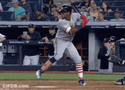 Baseball Player Swinging Bat At Ball With Crowd Watching GIF