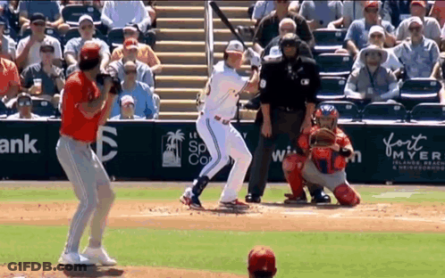 Baseball Player Swinging Bat While Catcher Watches GIF