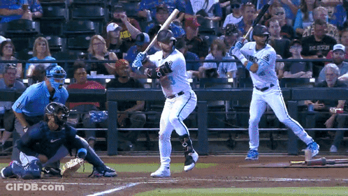 Baseball Player Swinging While Another Watches GIF