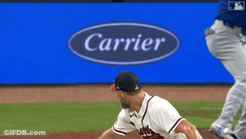 Baseball Player Throwing Pitch In Front Of Carrier Sign GIF