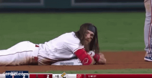 Baseball Player With Long Hair Lying On Ground GIF