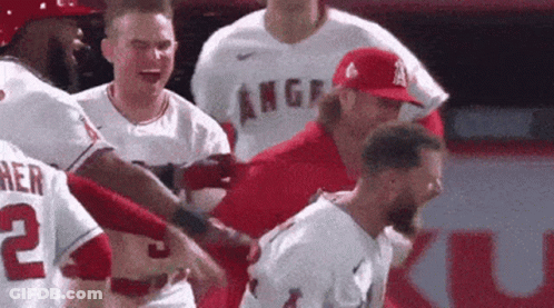 Baseball Players Around Man In Red Hat GIF