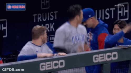 Baseball Players Hugging Behind Fence GIF