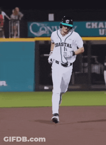 Baseball Players In Teal Shirts And Black Hats Watching Game GIF