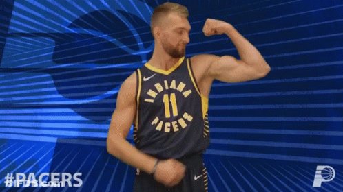 Basketball Player Flexing In Front Of Pacers Logo GIF