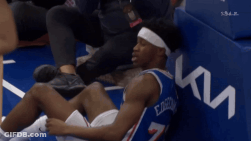 Basketball Player In Number 7 Jersey Sitting On Floor GIF