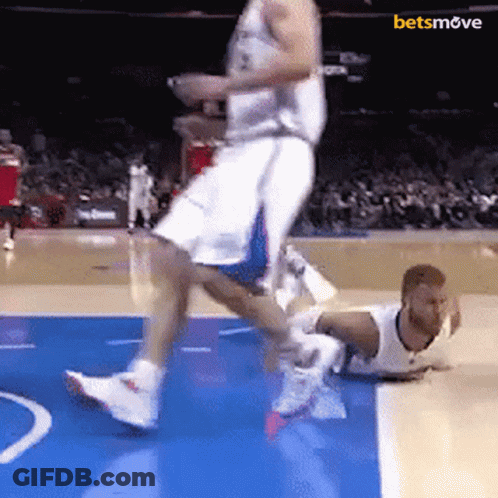 Basketball Player Jumps Over Downed Player GIF