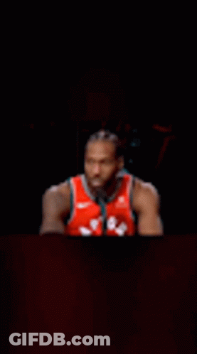 Basketball Player Sitting At Table In Dark Room GIF