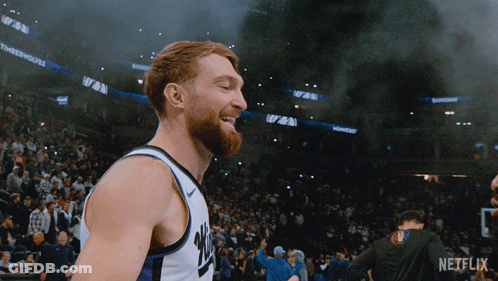 Basketball Player Smiling In Front Of Crowd With Netflix Logo GIF