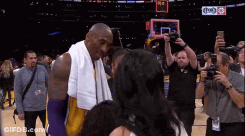 Basketball Player With Towel Talks To Woman At Fox Sports Scoreboard GIF