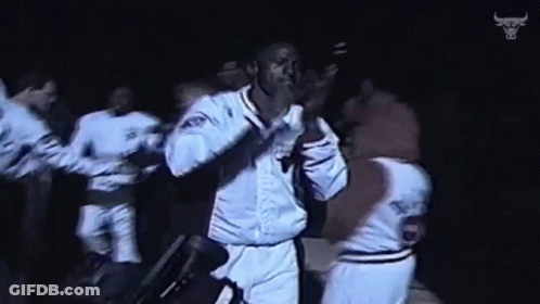 Basketball Players Dancing In Dark Room With Bull Logo GIF