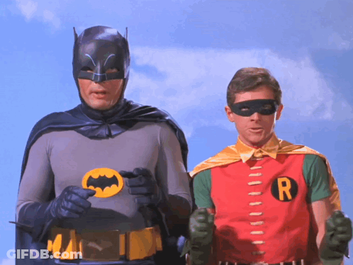 Batman And Robin Standing Together With R Shirt GIF
