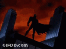 Batman Is Standing On The Roof Of A Building In A Storm . GIF