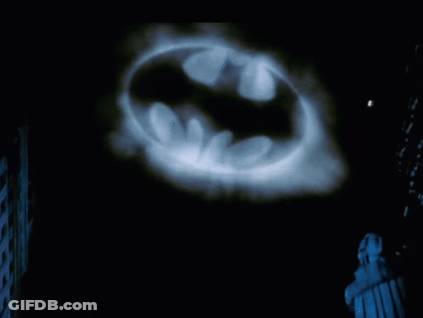 Batman Logo Projected On Dark Background GIF
