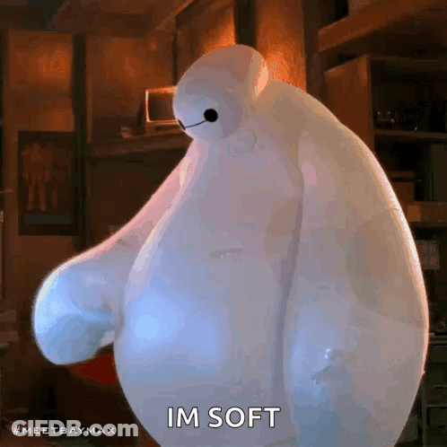 Baymax From Big Hero 6 Is Standing In A Room With His Arms Outstretched And Says `` Im Soft '' . GIF
