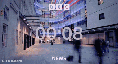 BBC News Screen With People Walking Past Building GIF