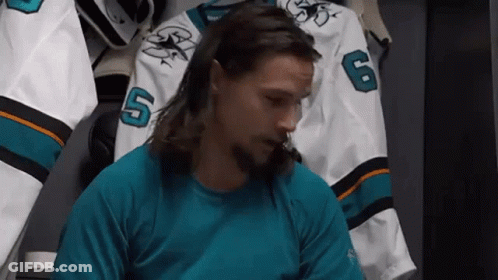 Bearded Long-Haired Man In Locker Room With Hockey Jersey GIF